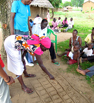 Volunteers and community members in Katakwi practicing the seasonal calendar tool